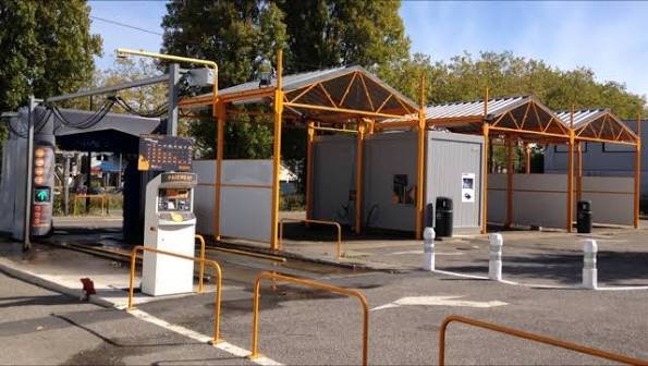Station de lavage automobile avec un portique de lavage à rouleaux et des pistes de lavage en libre-service